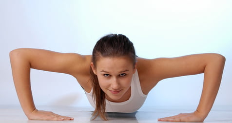 athletic lady doing a pushup with her hands inverted