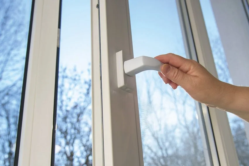 photo of hand on door handle with view of trees outside